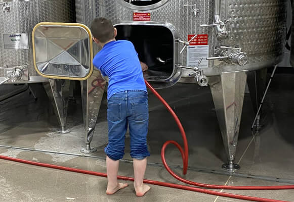 Boy cleaning wine tank