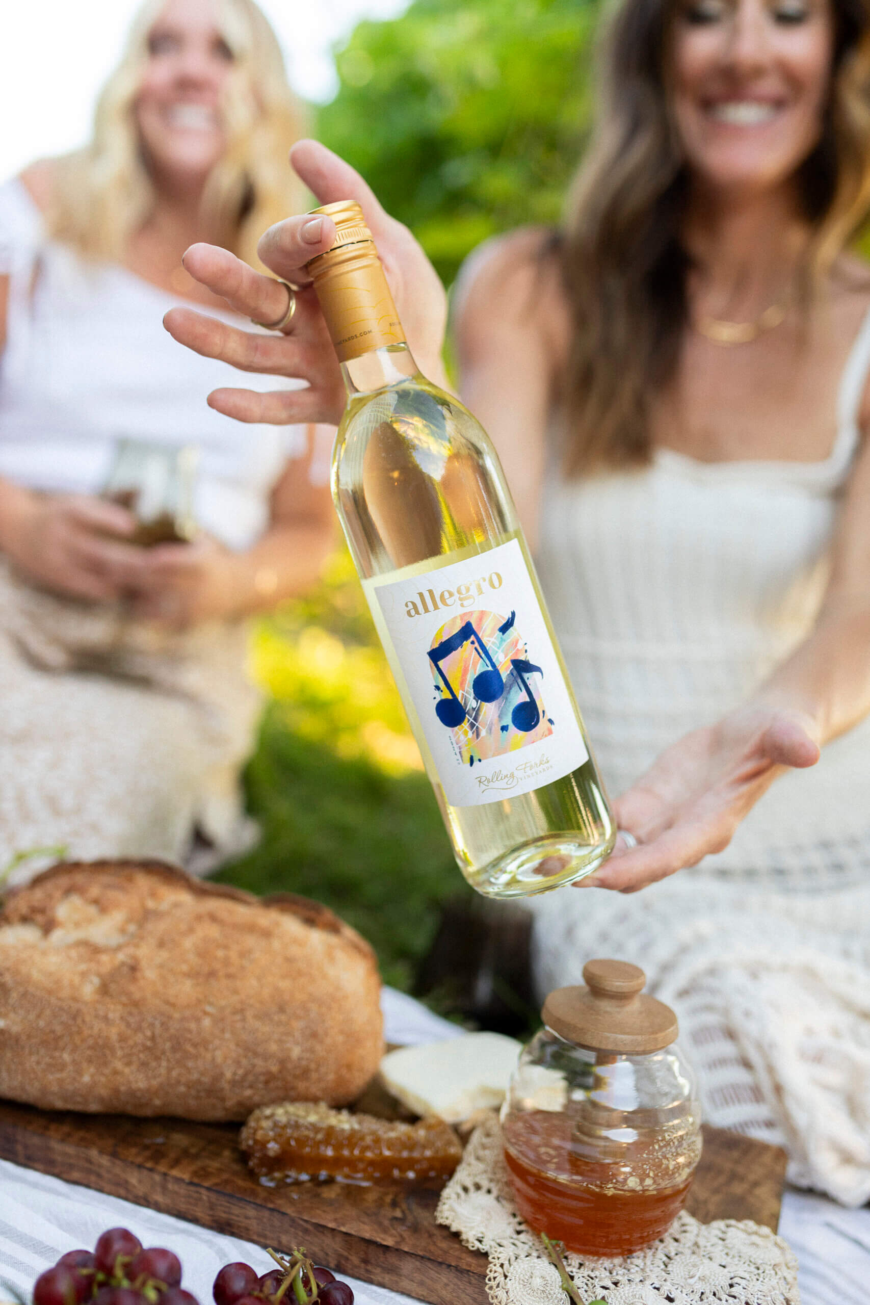 Ladies at a Picnic in the vineyard holding Allegro white wine by Rolling Forks vineyards, Glenwood, Minnesota